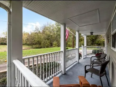 a porch with two chairs and an american flag at Updated 3bd Cottage on Bike Trail w/ River access! in Loveland