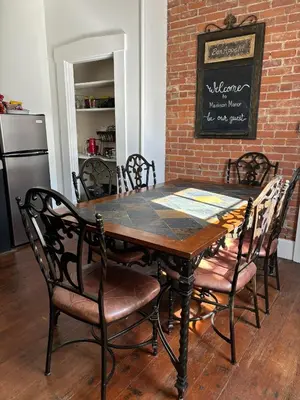 a dining room table with chairs and a brick wall at 