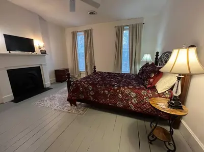 a bedroom with a bed and a lamp and a fireplace at 