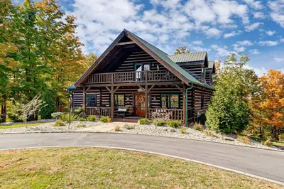 a large wooden house with a road in front of it at Large Log Cabin Chalet w/ Hot Tub - Horses & Lake! in Loveland