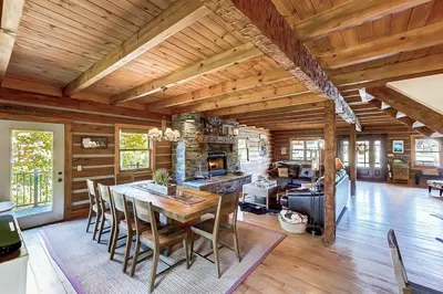 a dining room and living room with a table and chairs at Large Log Cabin Chalet w/ Hot Tub - Horses & Lake! in Loveland