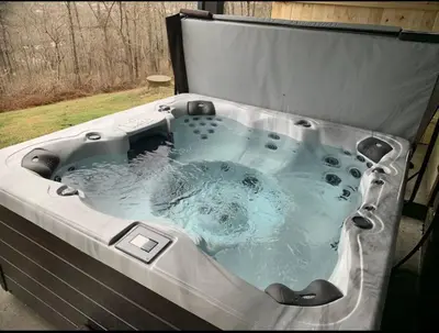 a large bath tub filled with water in a yard at Large Log Cabin Chalet w/ Hot Tub - Horses & Lake! in Loveland