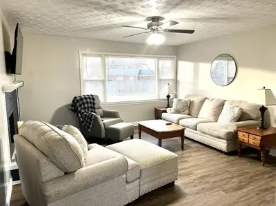 a living room with a couch and chairs and a ceiling fan at Charming Spacious Get Away in Shelbyville