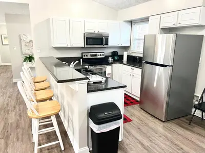 a kitchen with white cabinets and a stainless steel refrigerator at Charming Spacious Get Away in Shelbyville