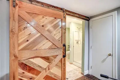 a wooden sliding door in a room with a bathroom at Beautiful Equestrian Estate home w/ Hot Tub! in Loveland