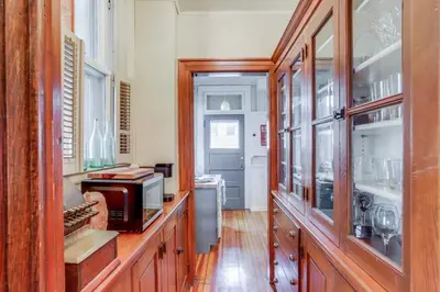 a kitchen with wooden cabinets and a microwave at Historic Tiffin Home about Half Mi to University! in Tiffin