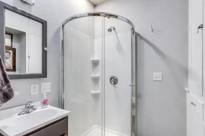 a white bathroom with a shower and a sink at Historic Tiffin Home about Half Mi to University! in Tiffin