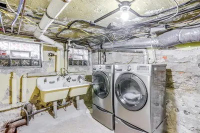a laundry room with a sink and a washing machine at Historic Tiffin Home about Half Mi to University! in Tiffin