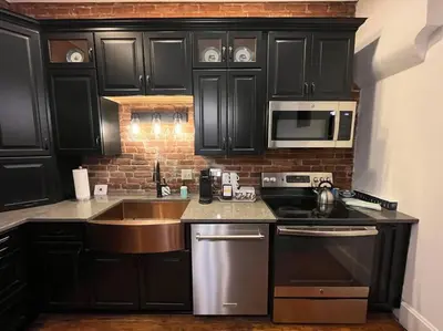 a kitchen with black cabinets and a sink at Madison Manor II by the River Hot Tub Downtown in Madison