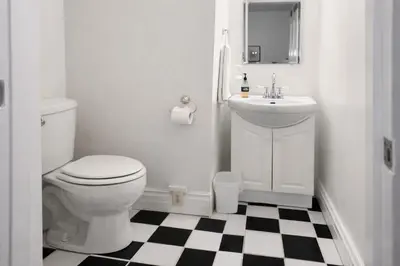 a white bathroom with a toilet and a sink at Madison Manor II by the River Hot Tub Downtown in Madison