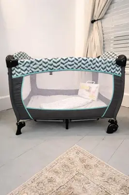a baby crib in a room with a rug at Madison Manor II by the River Hot Tub Downtown in Madison