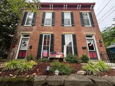 a red brick house with an american flag on it at Madison Manor II by the River Hot Tub Downtown in Madison