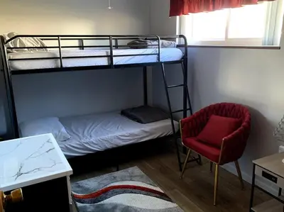 a bedroom with two bunk beds and a chair at Hidden Treasure in Scott Depot