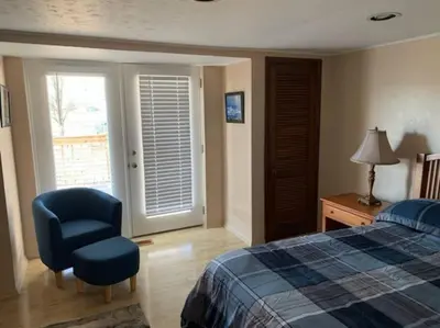 a bedroom with a bed and a chair and a window at Hidden Treasure in Scott Depot