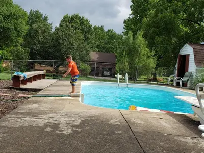a young boy standing next to a swimming pool at Hidden Treasure in Scott Depot