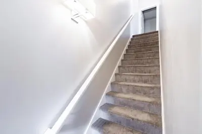 a staircase in a house with white walls and carpet at Luxury Downtown Townhome Unit 13 in Cleveland