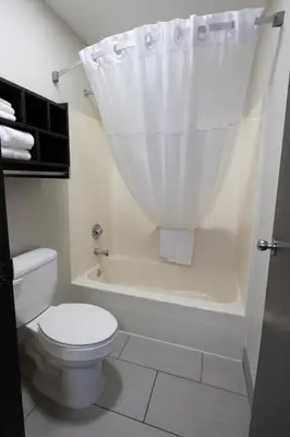 a bathroom with a toilet and a bath tub with a shower curtain at Days Inn by Wyndham Jackson in Jackson