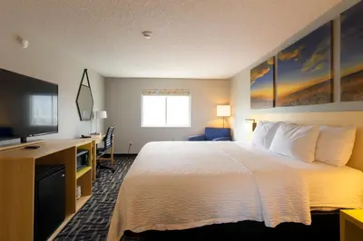 a hotel room with a bed and a desk and a television at Days Inn by Wyndham Jackson in Jackson