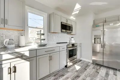 a kitchen with white cabinets and a stainless steel refrigerator at Waterfront Buckeye Lake Home with Deck and Dock! in Hebron
