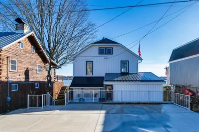 a large white house with a barn at Waterfront Buckeye Lake Home with Deck and Dock! in Hebron