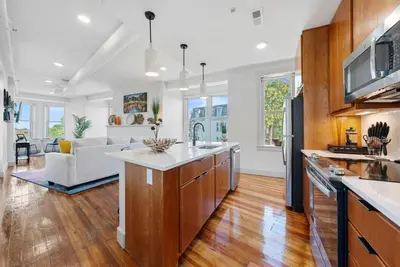 an open kitchen and living room with wooden floors at Flatiron Bldg - Views - Amazing Cafe - Near to ALL in Cincinnati