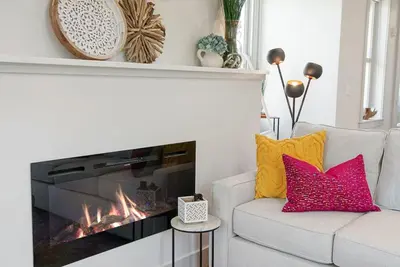 a living room with a white couch and a fireplace at Flatiron Bldg - Views - Amazing Cafe - Near to ALL in Cincinnati
