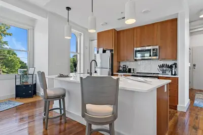 a kitchen with a large white island with chairs at Lux 1BR - Amazing Cafe - Views - Located near ALL in Cincinnati