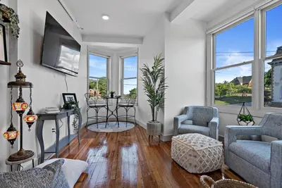 a living room with a couch and chairs and windows at Lux 1BR - Amazing Cafe - Views - Located near ALL in Cincinnati