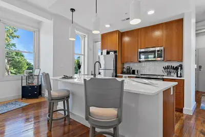 a kitchen with a large white counter and chairs at Lux 1BR - Amazing Cafe - Views - Located near ALL in Cincinnati