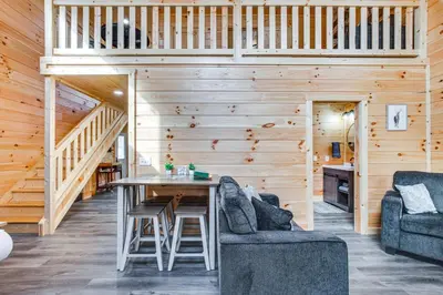 a wooden cabin with a table and two chairs at Modern Salineville Cabin on 13 Acres with Fire Pit! in Salineville