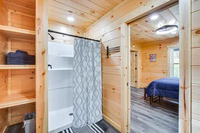 a log cabin with a bedroom and a bed at Modern Salineville Cabin on 13 Acres with Fire Pit! in Salineville