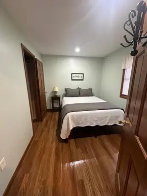 a bedroom with a bed and a wooden floor at The Mockingbird in Logan