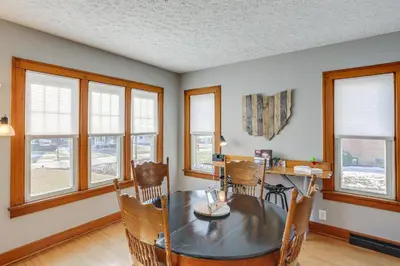 a dining room with a table and chairs and windows at Cozy Tiffin House with Private Pool 1 Mi to Town! in Tiffin