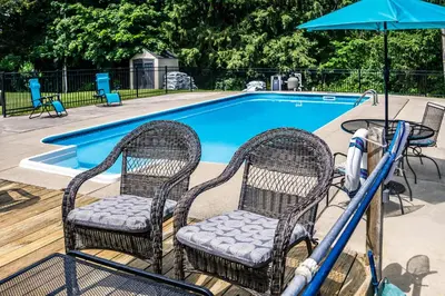 a pool with two chairs and an umbrella at Cozy Tiffin House with Private Pool 1 Mi to Town! in Tiffin