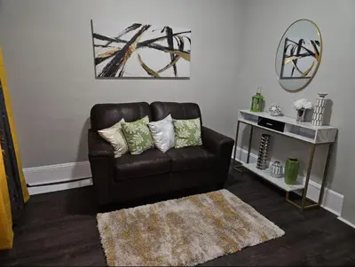 a living room with a brown leather couch and a rug at Elegant 4 Bed Room at Cleveland Clinic Area in Cleveland