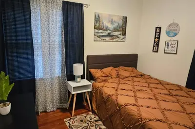 a bedroom with a bed and a table with a lamp at Lovely 3 Bed Room in Cleveland in Cleveland Heights