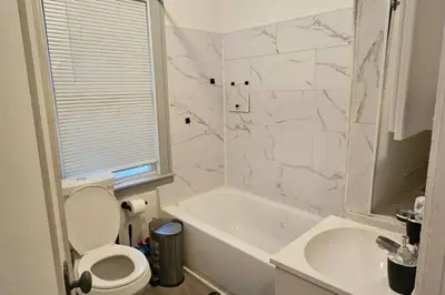 a bathroom with a toilet and a tub and a sink at Lovely 3 Bed Room in Cleveland in Cleveland Heights