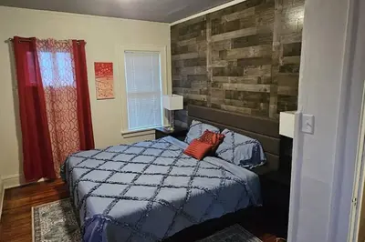 a bedroom with a blue bed with a brick wall at Lovely 3 Bed Room in Cleveland in Cleveland Heights
