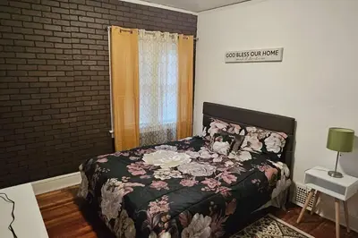 a bedroom with a bed with a floral comforter at Lovely 3 Bed Room in Cleveland in Cleveland Heights
