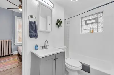 a white bathroom with a sink and a toilet at Historic Cozy Haven in Little Italy in Cleveland