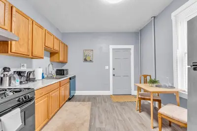 a kitchen with wooden cabinets and a wooden table at Historic Cozy Haven in Little Italy in Cleveland