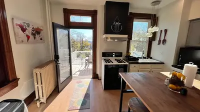 a kitchen with a table and a stove top oven at Skyline Retreat Spacious Elegance Queen Suite 1 City Views in Cincinnati