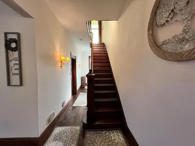 a hallway with a staircase with a mirror on the wall at Skyline Retreat Spacious Elegance Queen Suite 1 City Views in Cincinnati