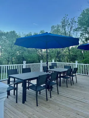 a table and chairs with an umbrella on a deck at Skyline Retreat Spacious Elegance Queen Suite 1 City Views in Cincinnati