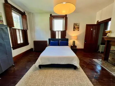 a bedroom with a bed with blue pillows at Skyline Retreat Spacious Elegance Queen Suite 1 City Views in Cincinnati