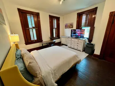 a bedroom with a bed and a flat screen tv at Skyline Retreat Spacious Elegance Queen Suite 3 City Views in Cincinnati