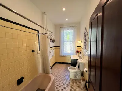 a bathroom with a tub and a toilet and a sink at Skyline Retreat Spacious Elegance Queen Suite 3 City Views in Cincinnati