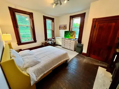 a bedroom with a bed and a television in it at Skyline Retreat Spacious Elegance Queen Suite 3 City Views in Cincinnati