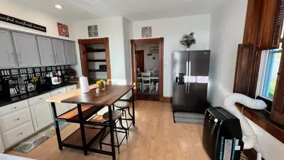 a kitchen with a wooden table and a refrigerator at Skyline Retreat Spacious Elegance Queen Suite 3 City Views in Cincinnati