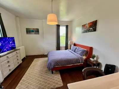 a bedroom with a bed and a television in it at Skyline Retreat Spacious Elegance Queen Suite 4 City Views in Cincinnati